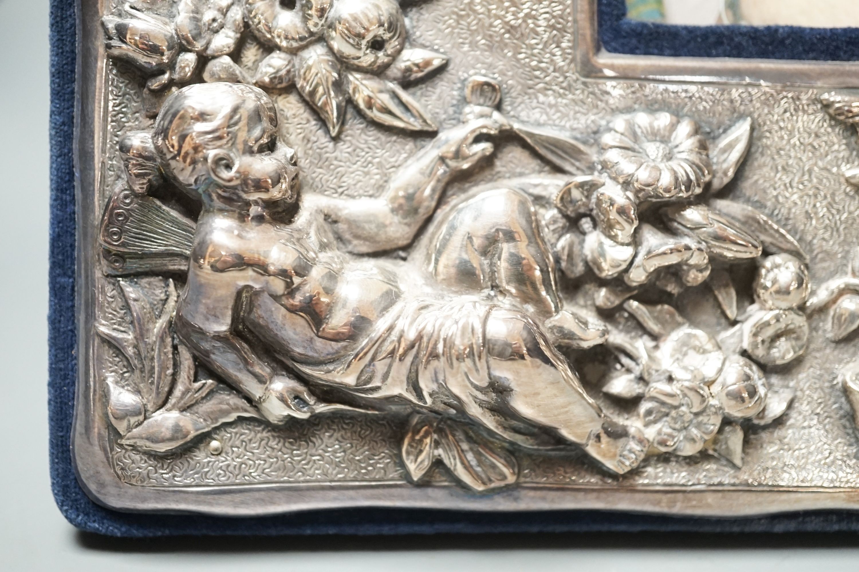 A modern sterling mounted photograph frame boldly embossed with cherubs, width 27.2cm.